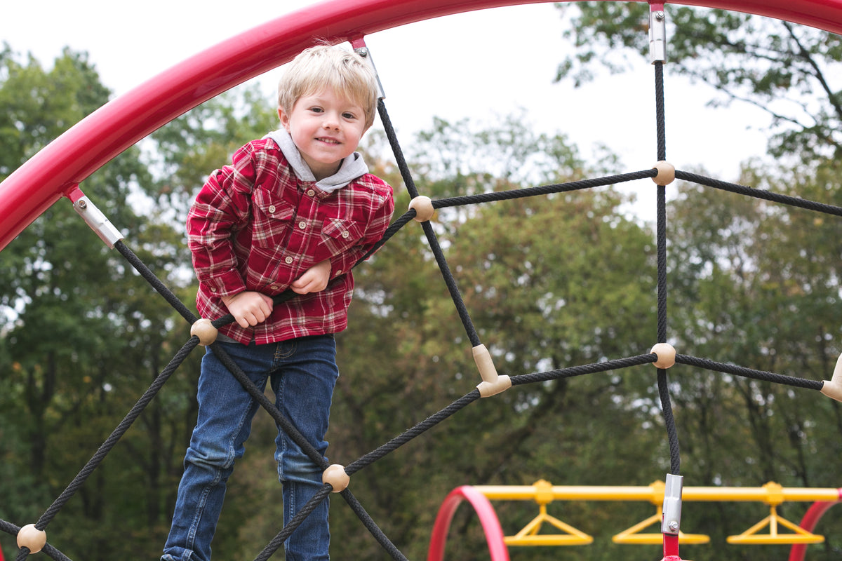 Child climbing on a playground web
